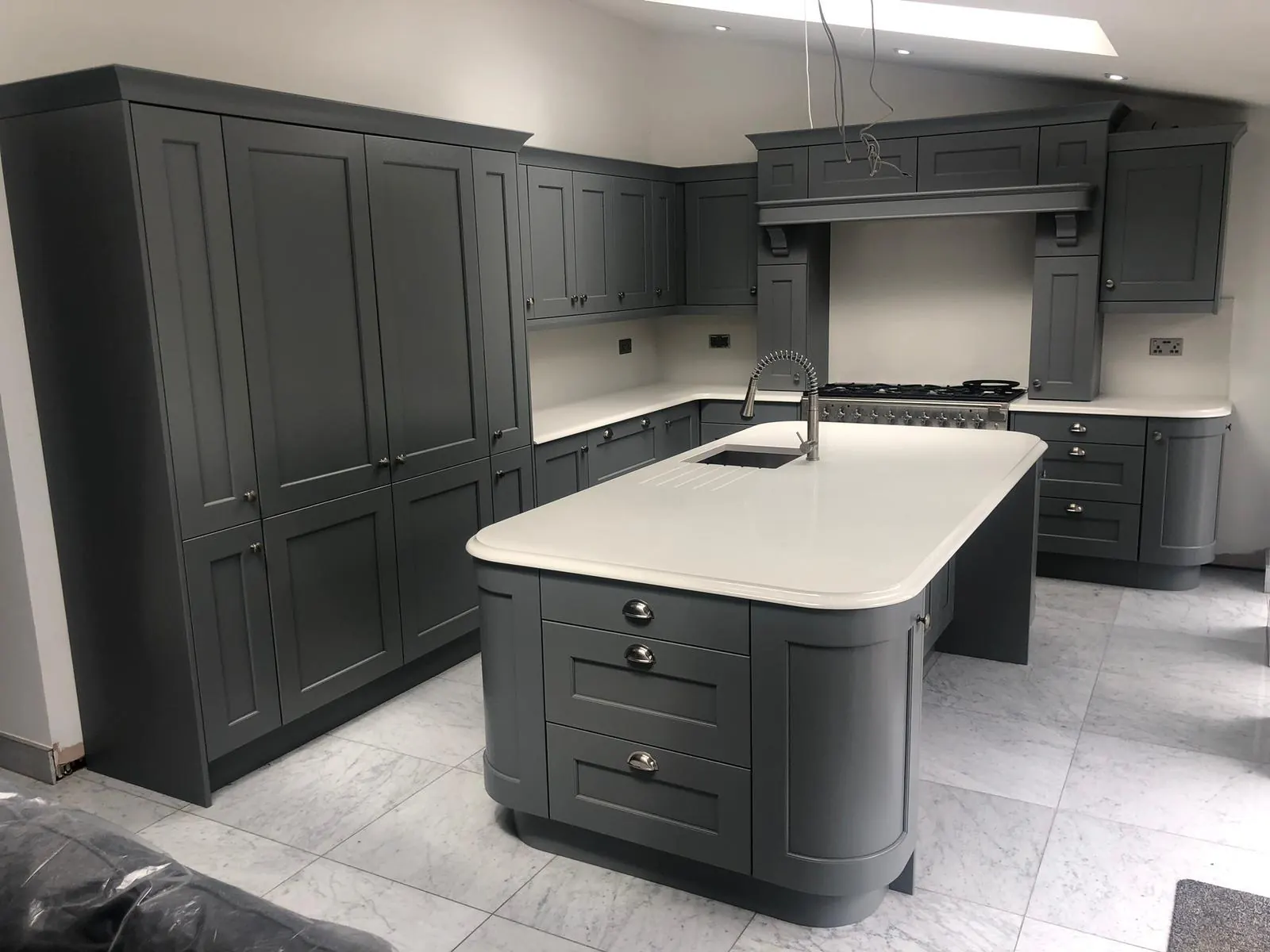 Handleless kitchen in deep navy with quartz worktop, fitted by Thomas Howie in Ainsdale