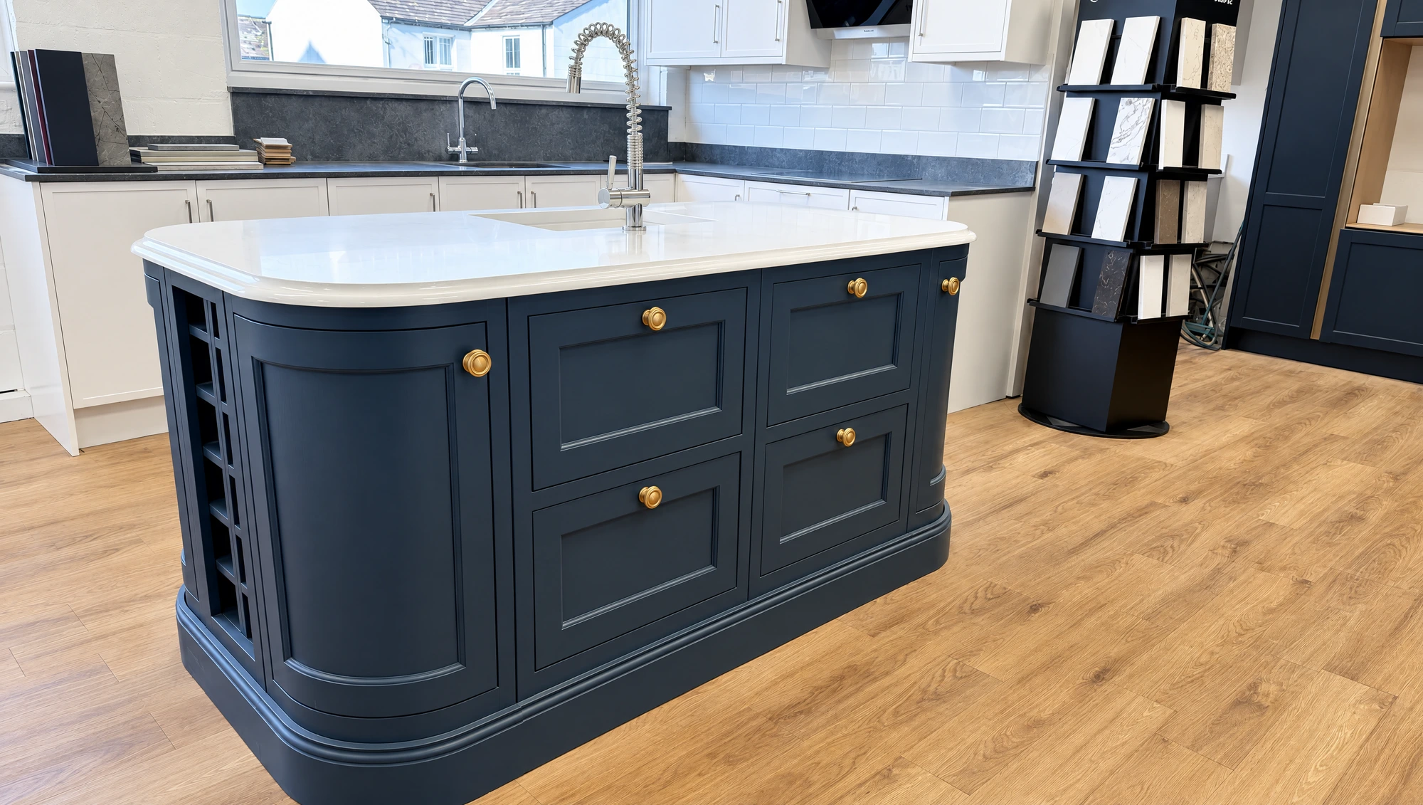 Thomas Howie navy blue bespoke kitchen island with white quartz top and brass knobs